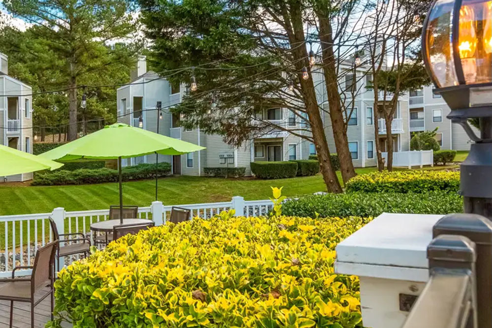 Landscaped courtyard with lawn, patio seating and apartment buildings