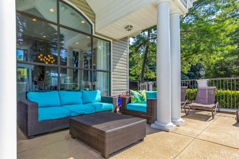Covered patio with wicker sofa and armchairs outside the clubhouse